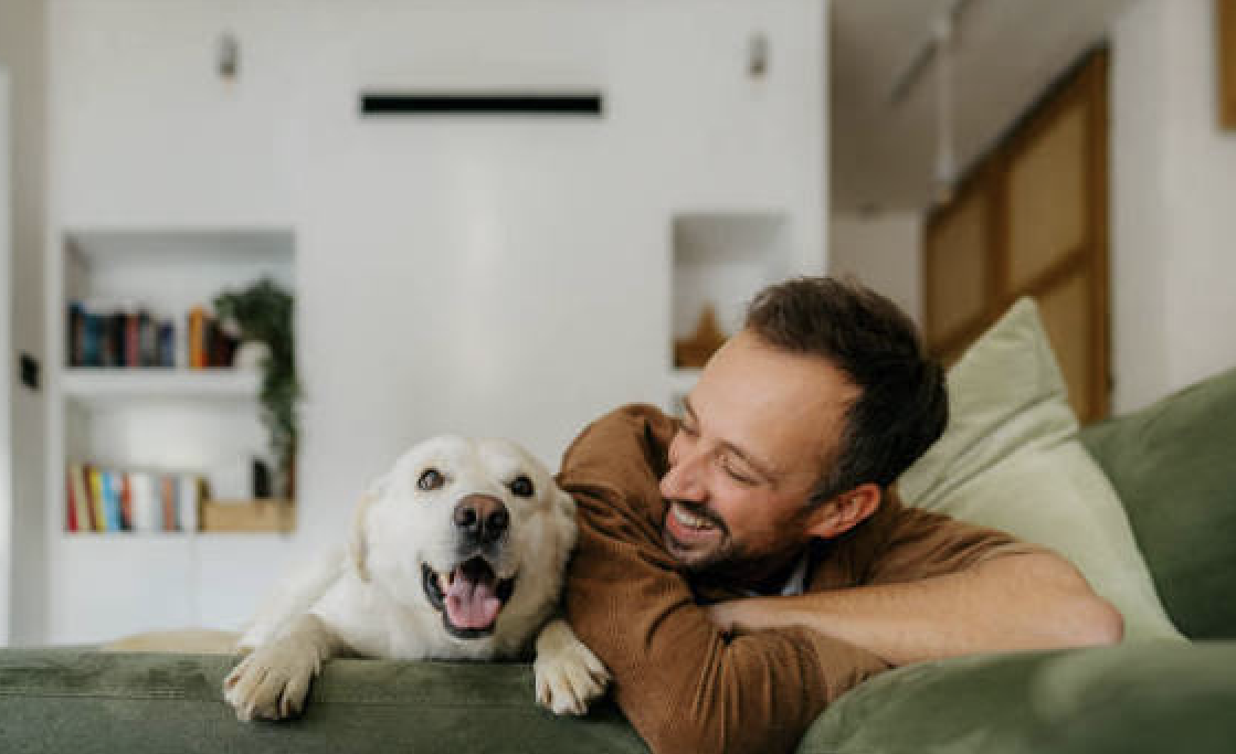 Resident relaxing with their dog on the sofa at home